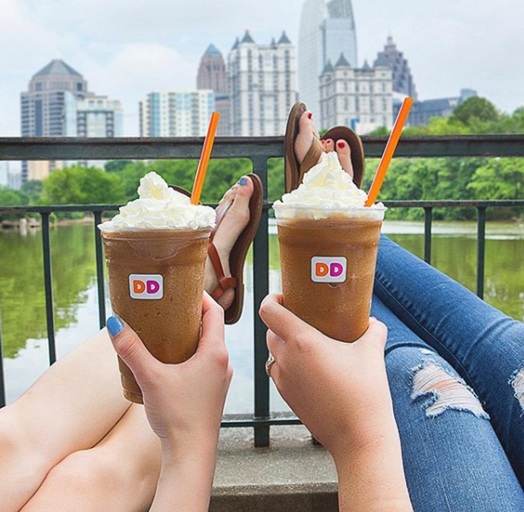 2 girls sitting with drinks from Dunkin Donuts
