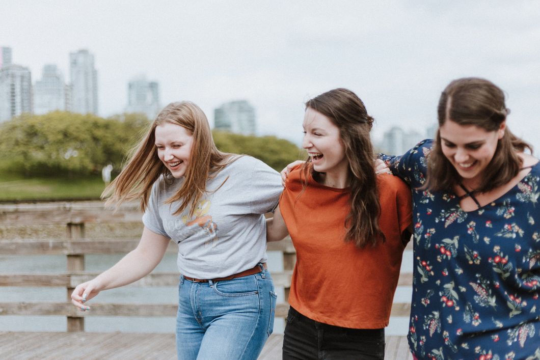 3 women holding each other and laughing