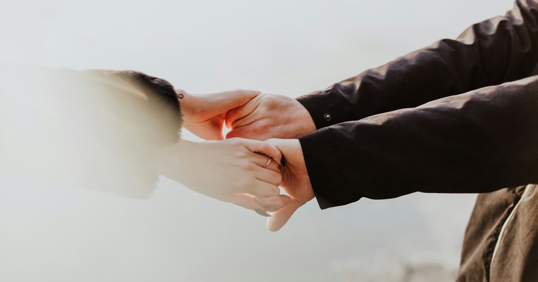 A couple holding hands while standing next to each other