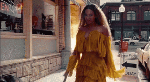 A gif of Beyonce walking through the street with a baseball bat