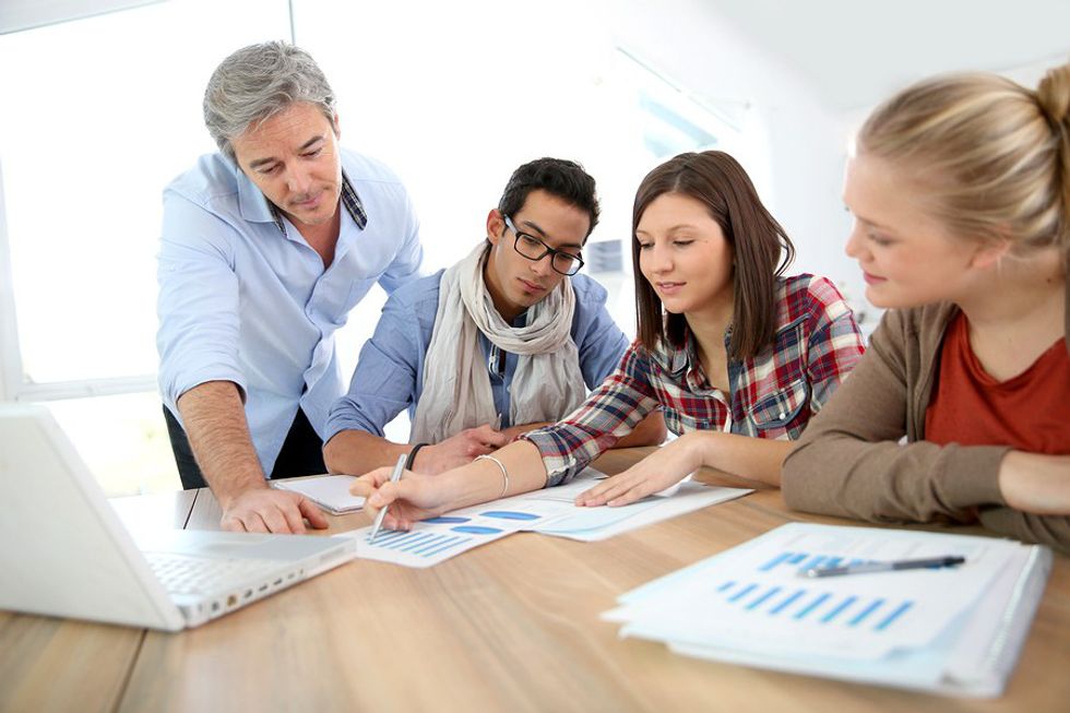 a group of people review documents in a meeting