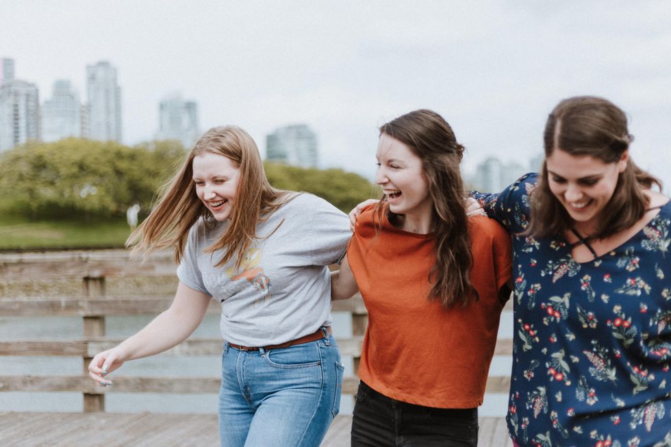 A group of the women smiling with their arms linked