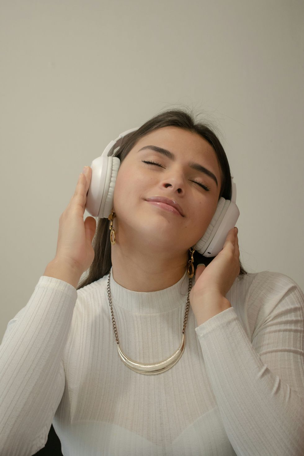 A lady wearing white headphones listening to music