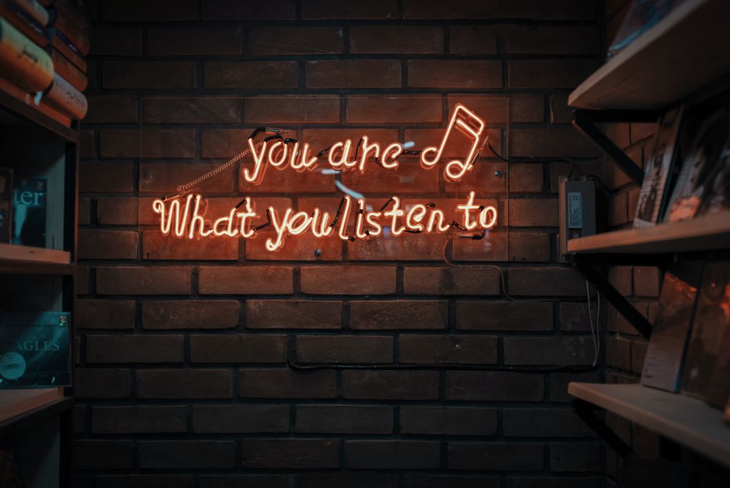 A picture of a brick wall with the saying you are what you listen to
