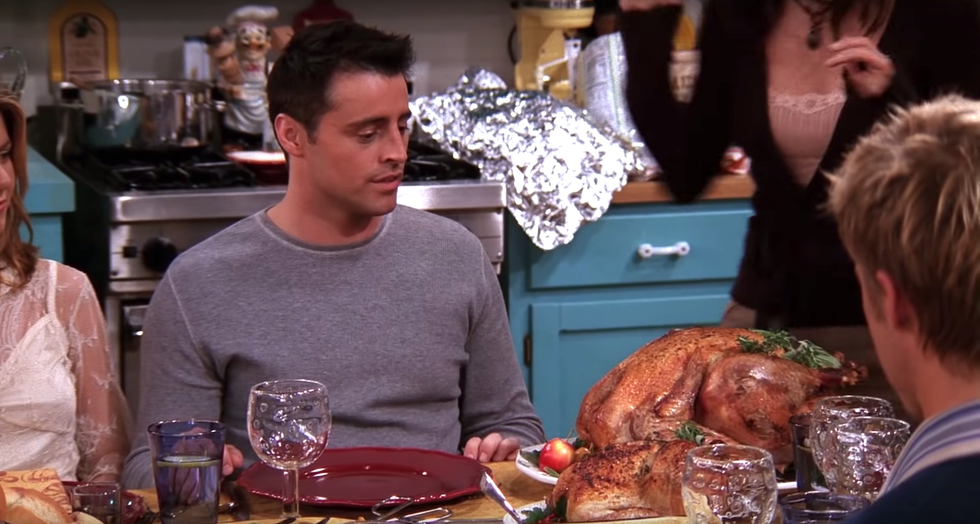 A plate of flower shaped squash on a dark wood table with a bowl of pumpkins sitting next to it