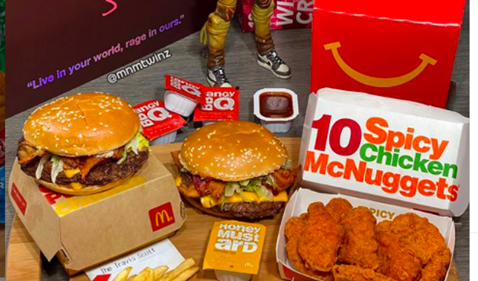 a table with a box of nuggets labeled "10 spicy chicken McNuggets" on it and two burgers next to them