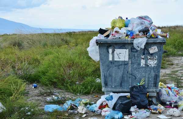 A trash bin overflowing with waste.