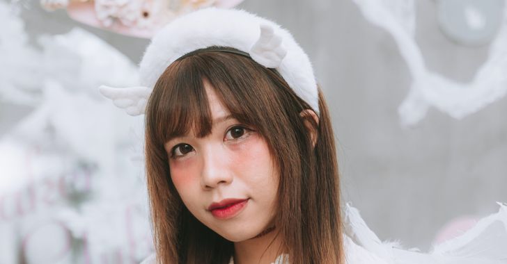 A woman in a white dress and angel wings