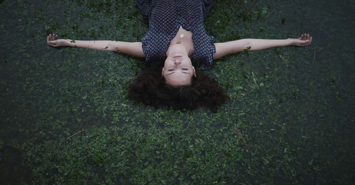 a woman laying on the ground with her eyes closed