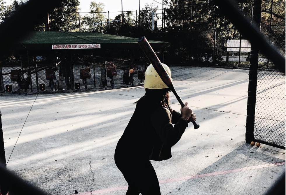 A woman preps to hit a baseball at the Pioneer Park batting cages.