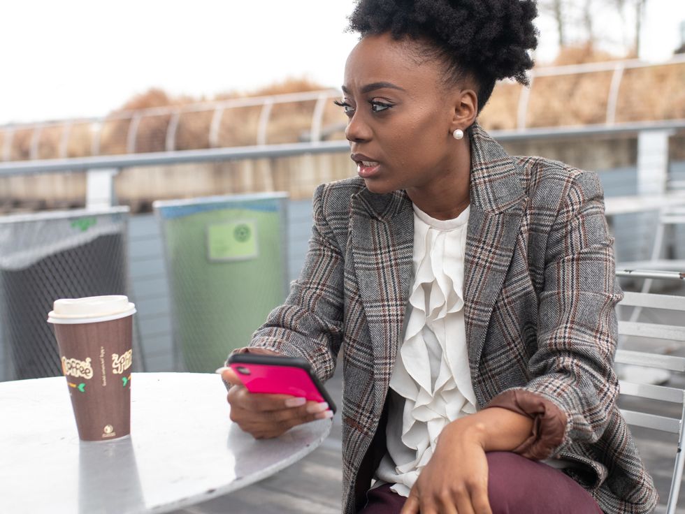 a woman sitting at a table having a coffee