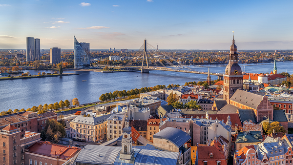 Aerial view of Riga, Latvia with river, bridge, under a clear blue sky.