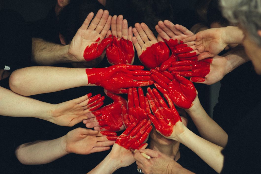 All human beings hands together painted in red. 