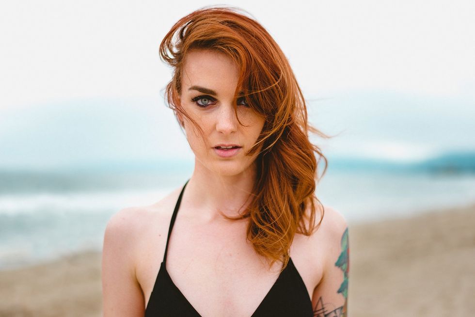 attractive beautiful redhead model on summer beach