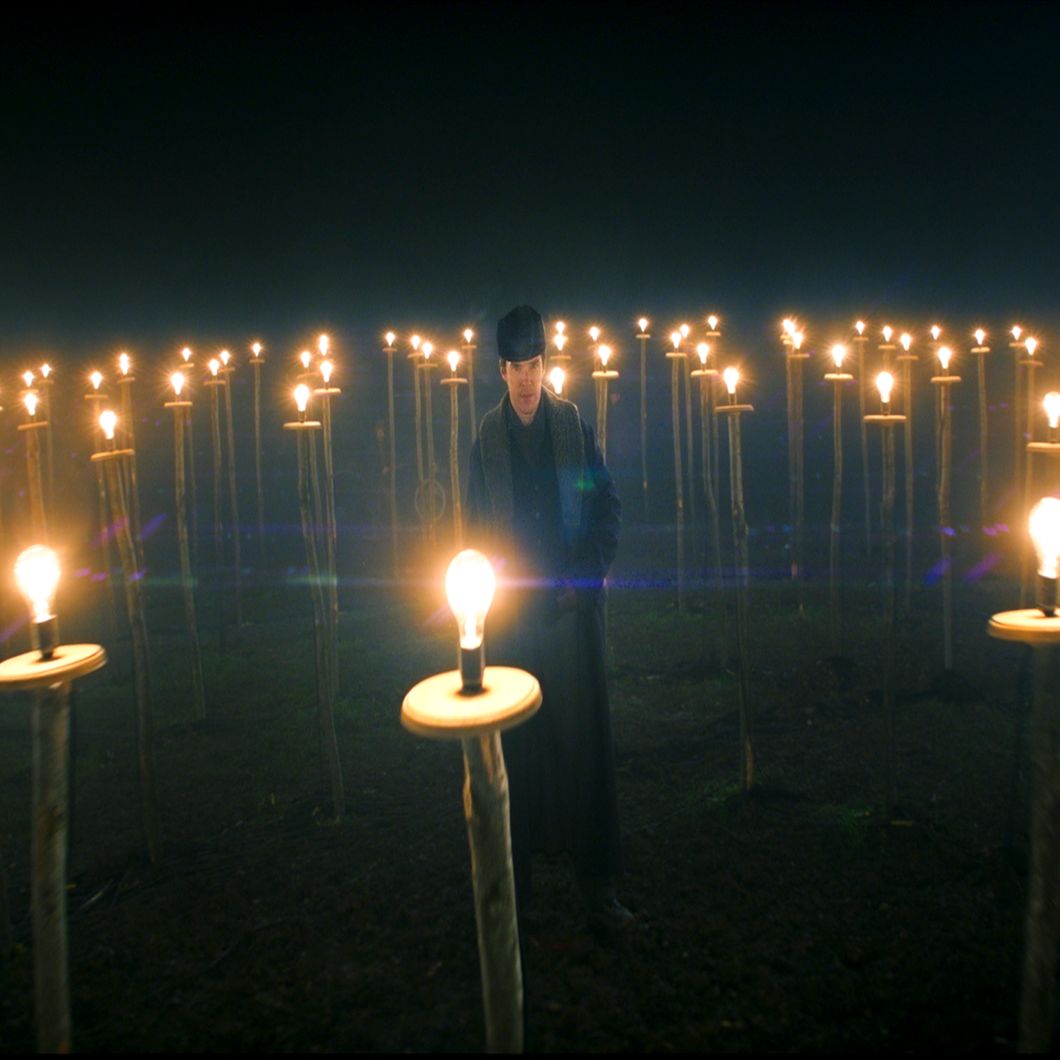 Benedict Cumberbatch as Thomas Edison stands in an open field surrounded by numerous lightbulbs on stands in "The Current War: Director's Cut."