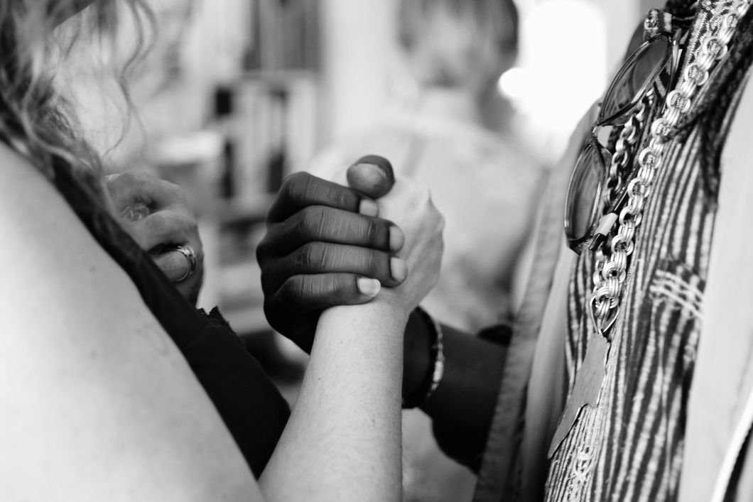 Black woman and white woman holding hands