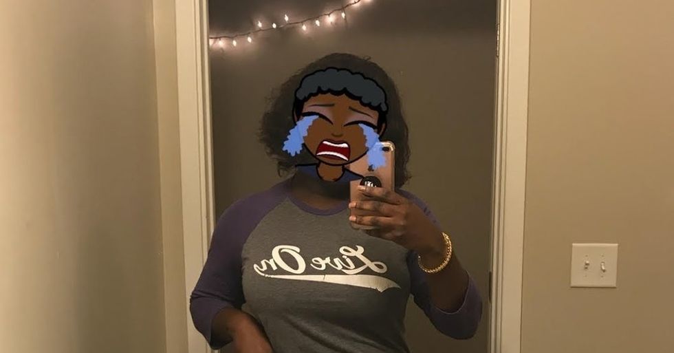 black woman taking selfie in mirror with crying bitmoji face