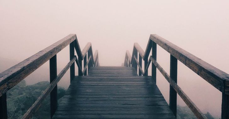 Black wooden stairway covered with fog