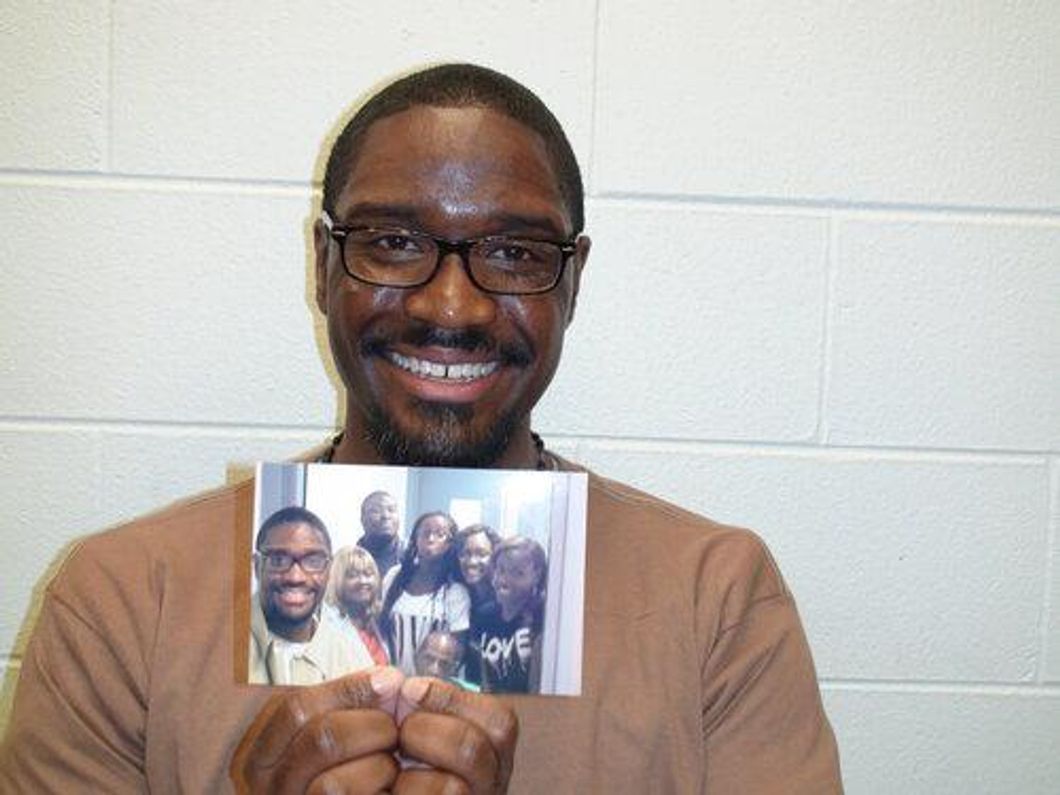 Brandon Bernard holding a photo of him with his family