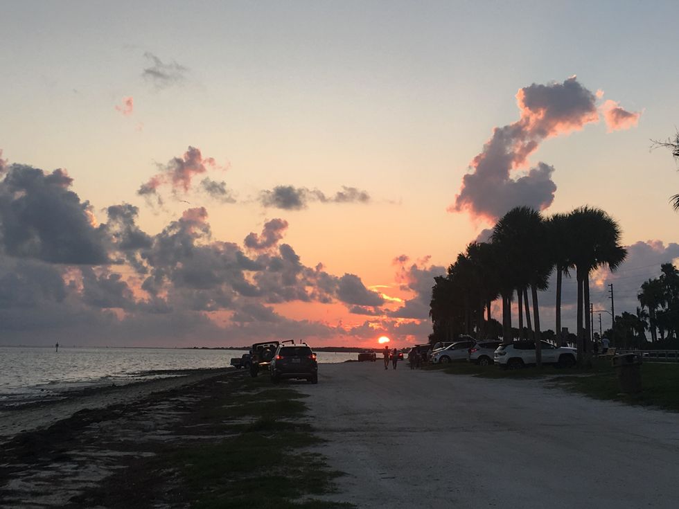 cars on beach at sunset