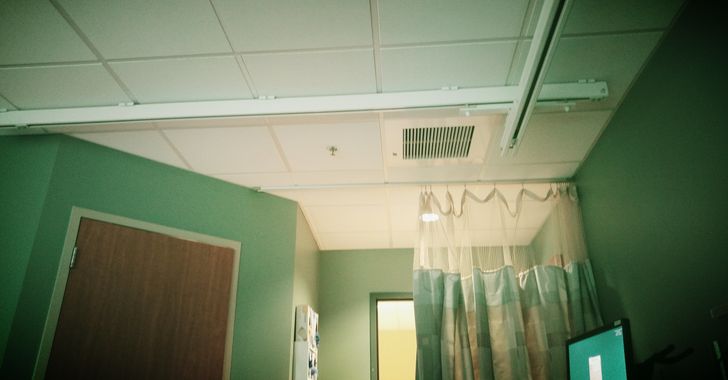 Ceiling of a hospital room with the top of a curtain and a door closed