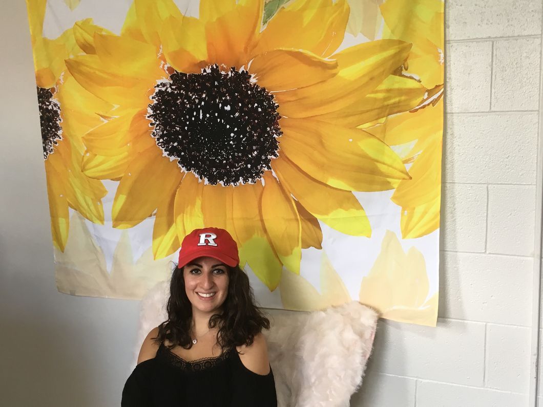 Christine sitting in her dorm room, in front of a sunflower decoration