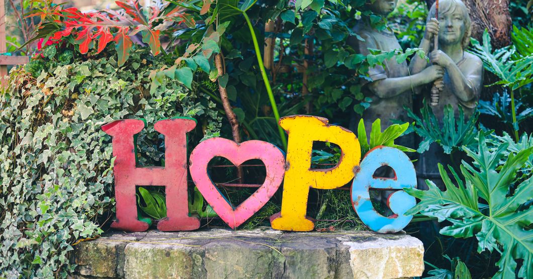 Colorful large standing letters that say hope in a garden 