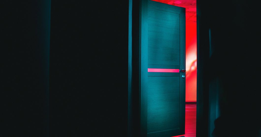 Dark room with open door and red light shining through