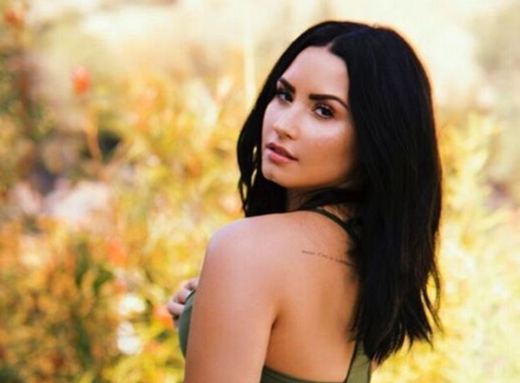 Demi Lovato posing near flowers