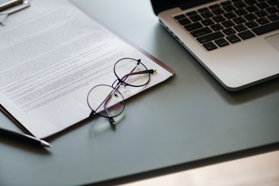 desk with laptop letter and glasses