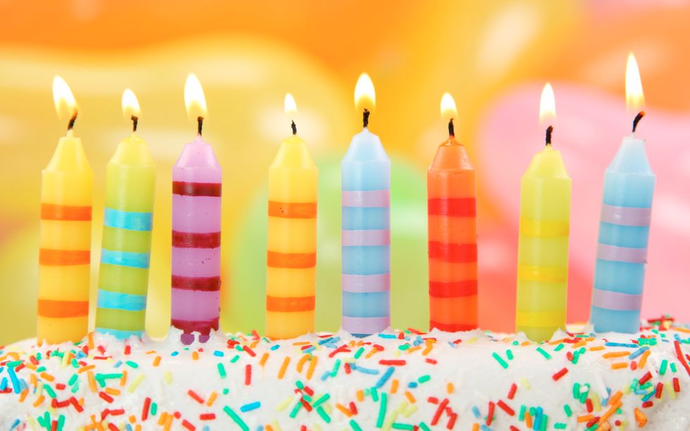​different color birthday candles on a cake