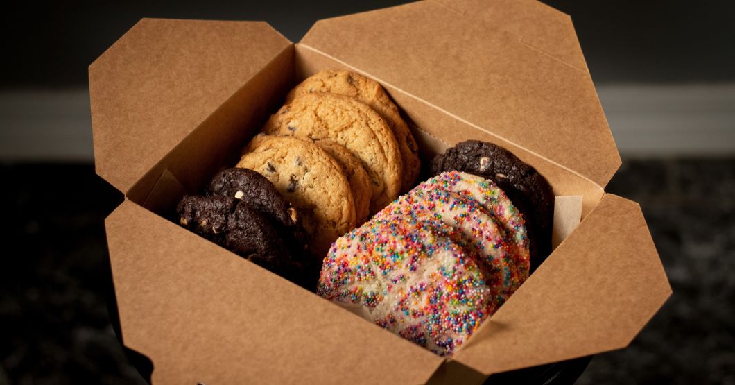 Different flavor round cookies in a square brown open box