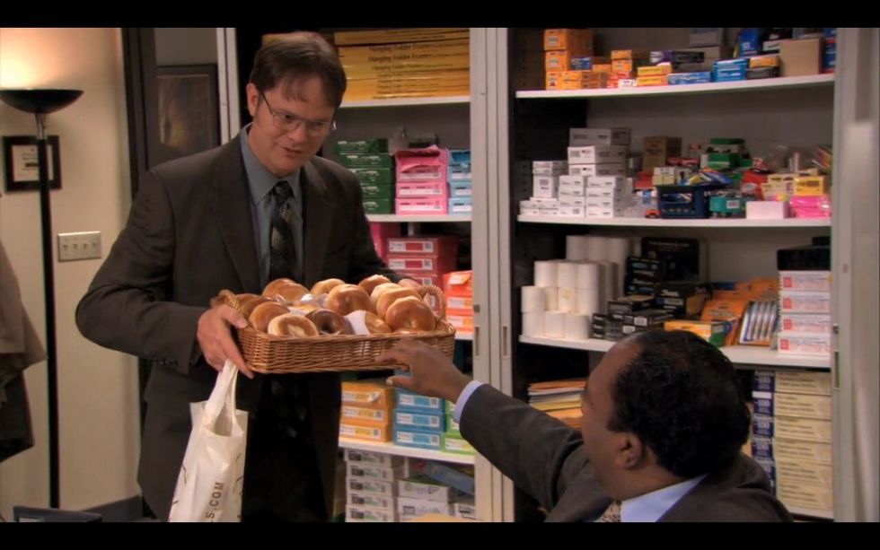 Dwight from "The Office" holding a basket filled with bagels