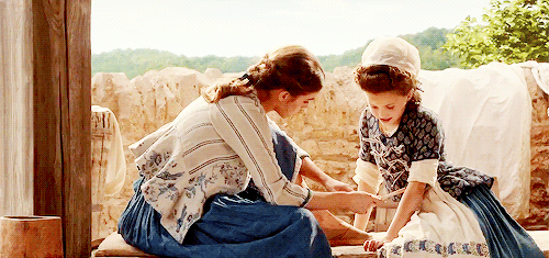 Belle teaches a young village girl how to read.