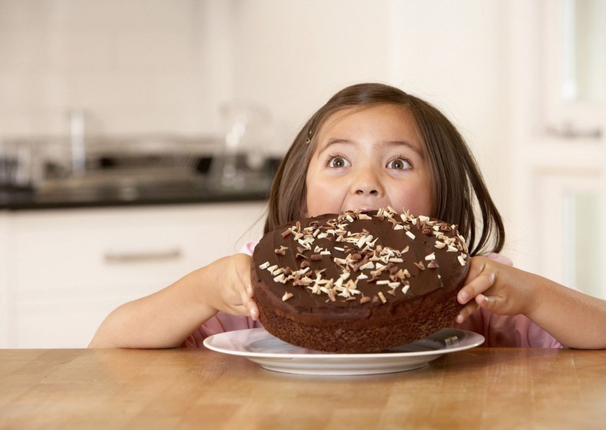 little girl enjoys delicious chocolate cake