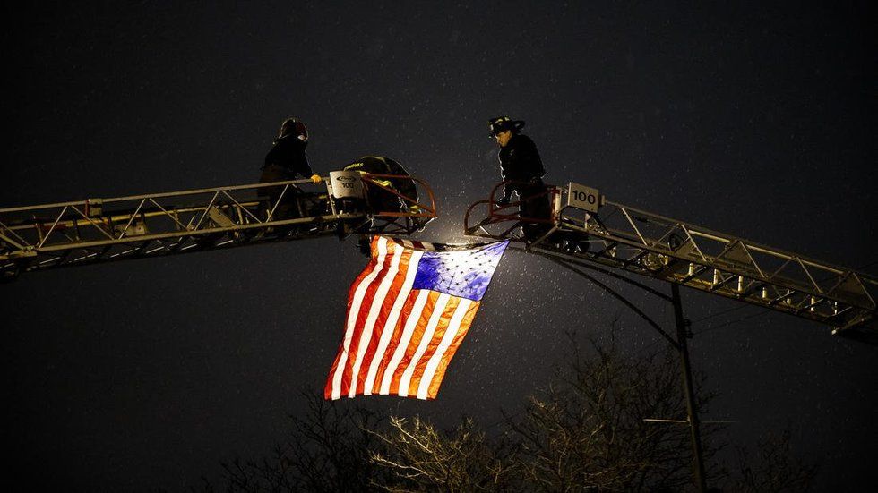 Firemen raising flag for fallen officer