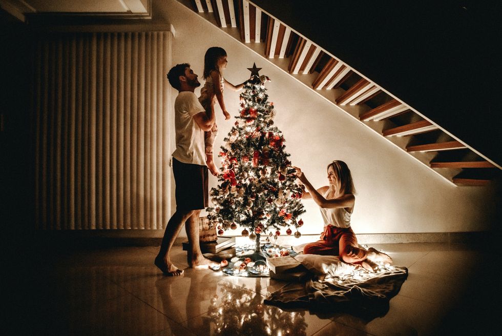 family decorates christmas tree together