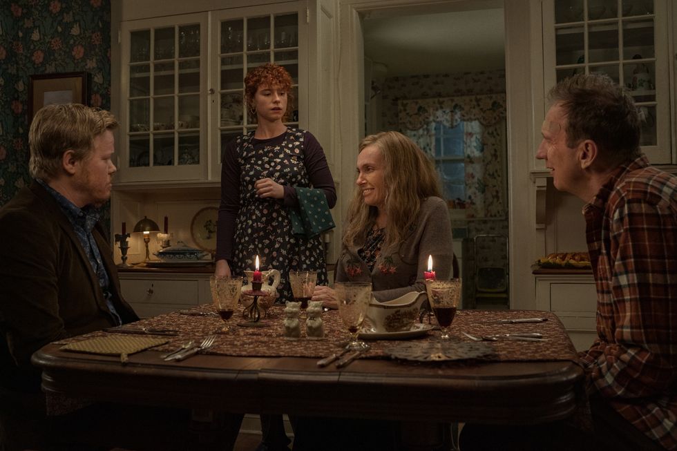 (From left to right) Jesse Plemons as Jake, Jessie Buckley as Young Woman, Toni Collette as Mother, David Thewlis as Father in "I'm Thinking Of Ending Things." Everyone except for the young woman is sitting around a candlelit table for dinner.