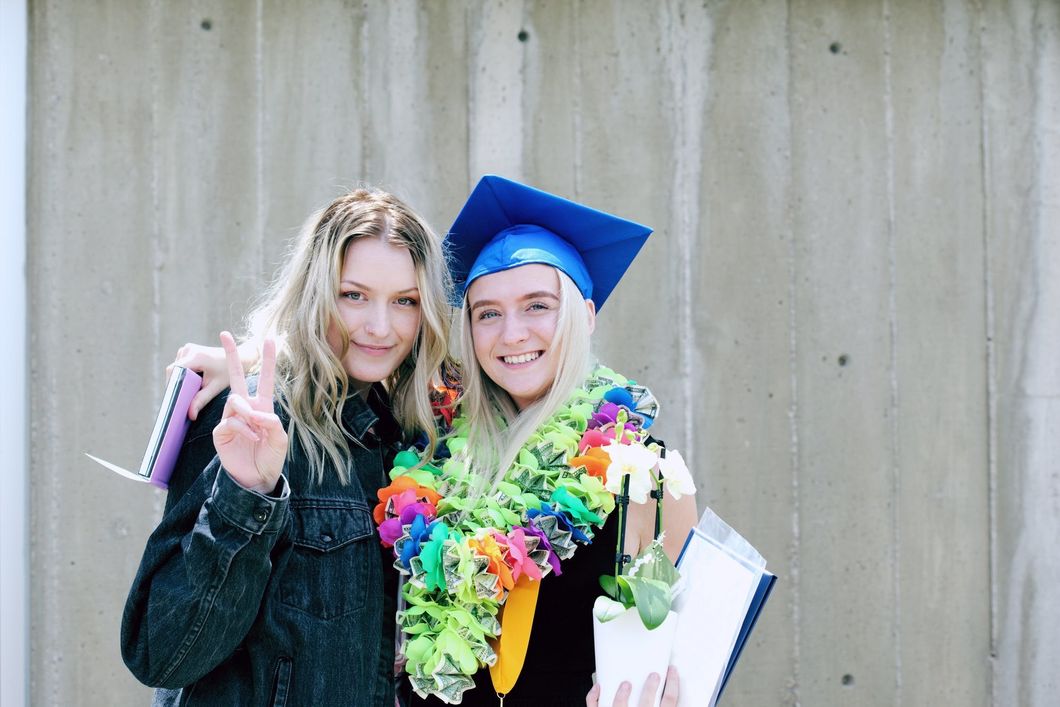 girl graduating posing with friend for photo