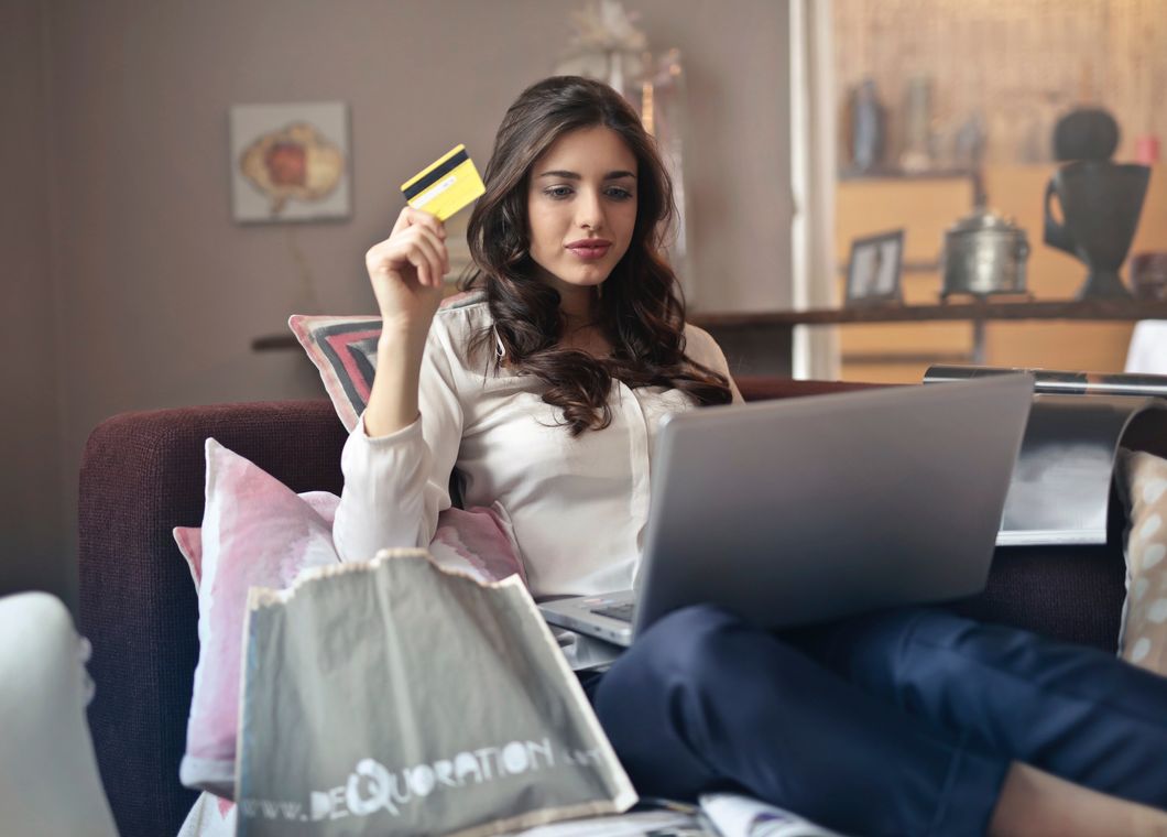 Girl holding credit card and laptop