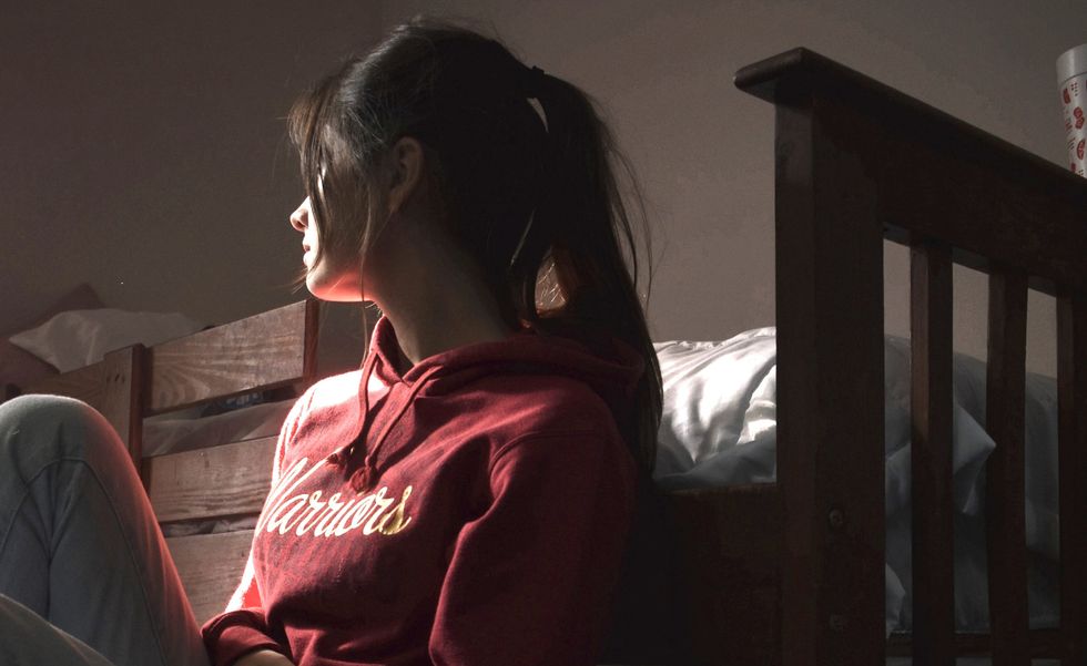 Girl in a red hoodie sitting on the floor