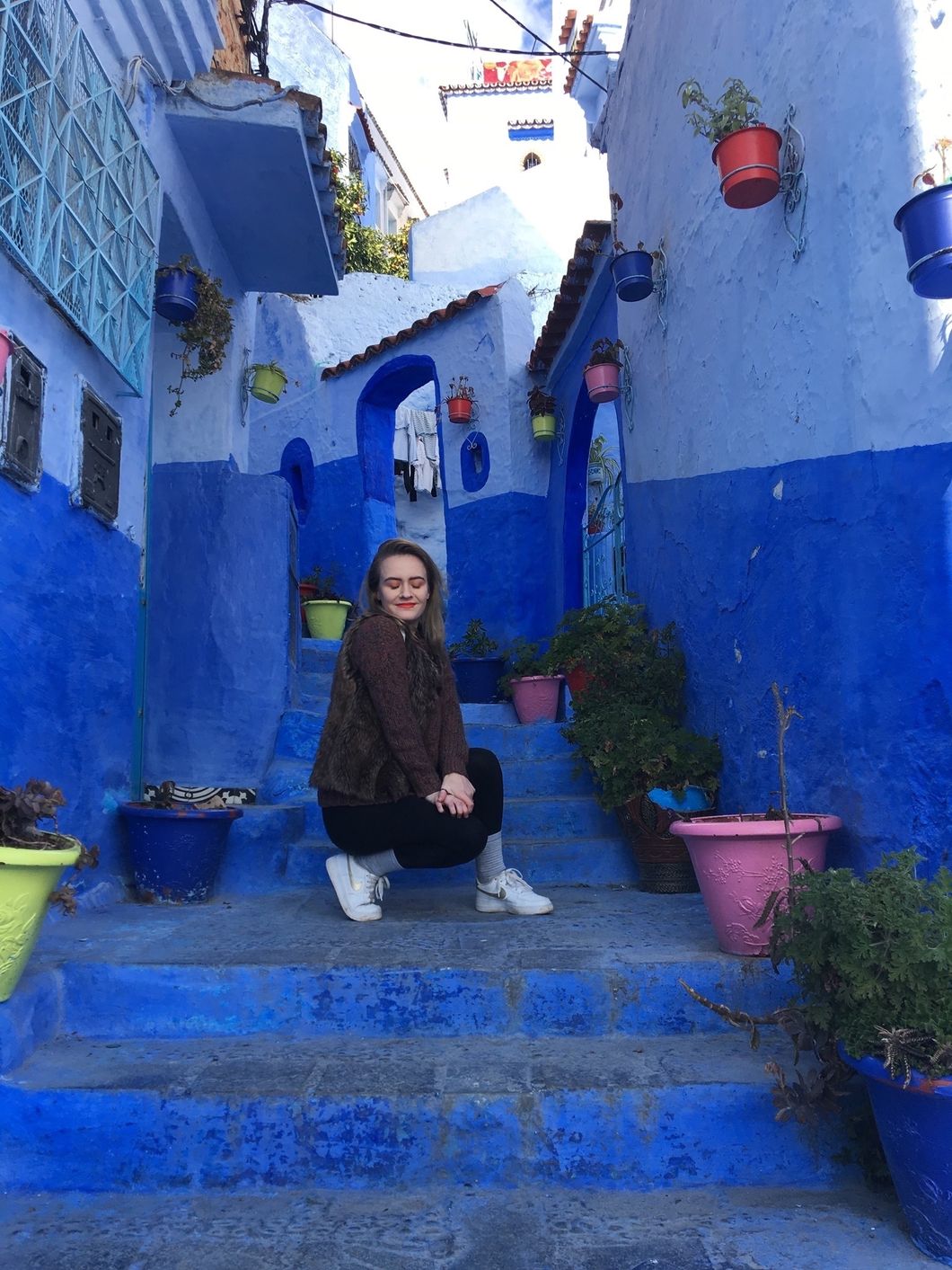 girl in Moroccan alleyway with flowerpots