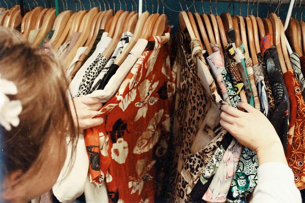 girl looking through a rack of clothes