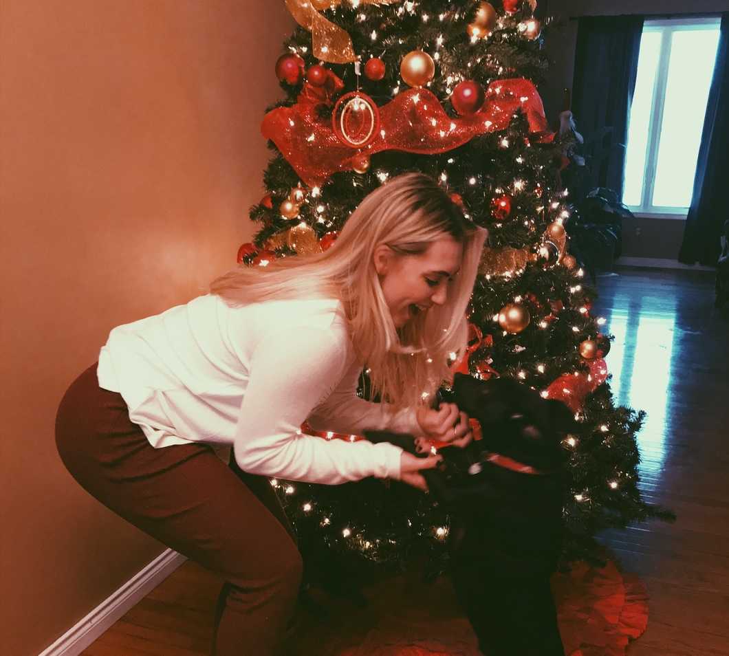 Girl with dog by the Christmas tree