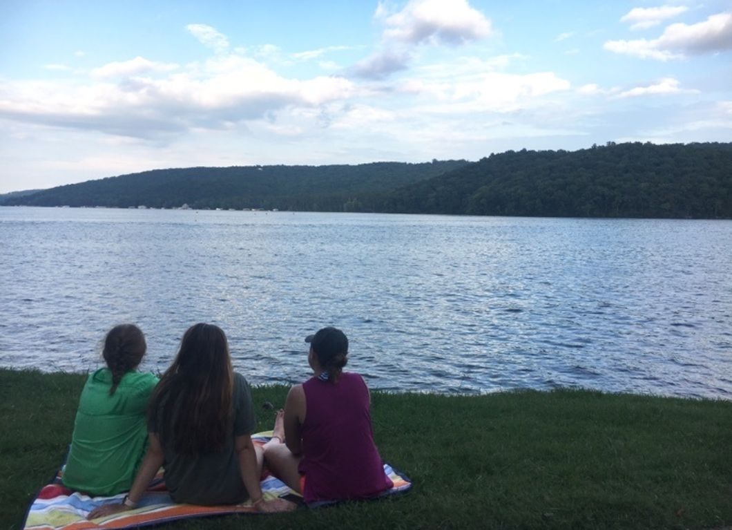 girls facing lake and sky