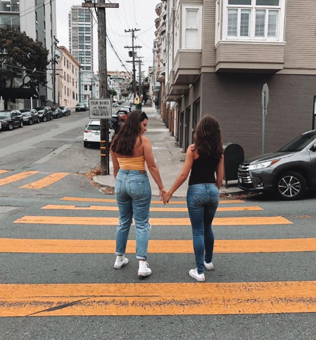 girls holding hands walking through san francisco