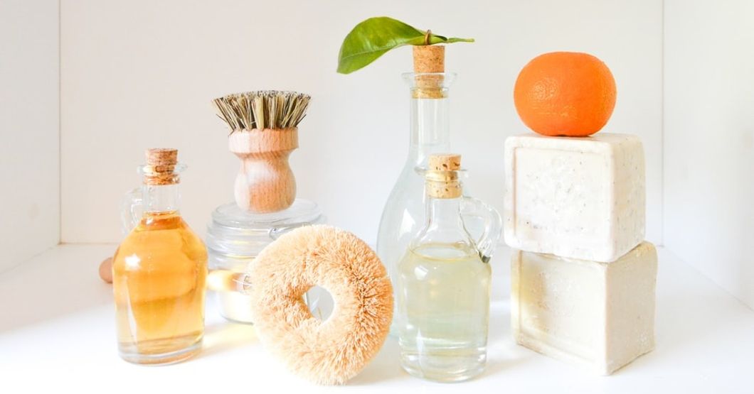 glass bottles of various sizes containing soap, bar soaps, and skin exfoliating brushes.