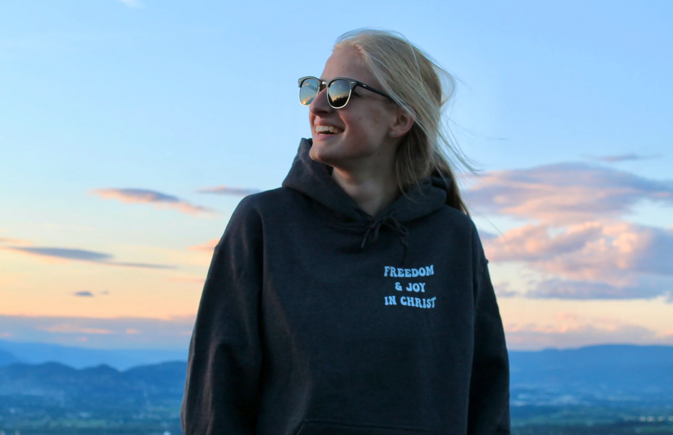 God above all owner wearing their freedom & joy in Christ black hoodie