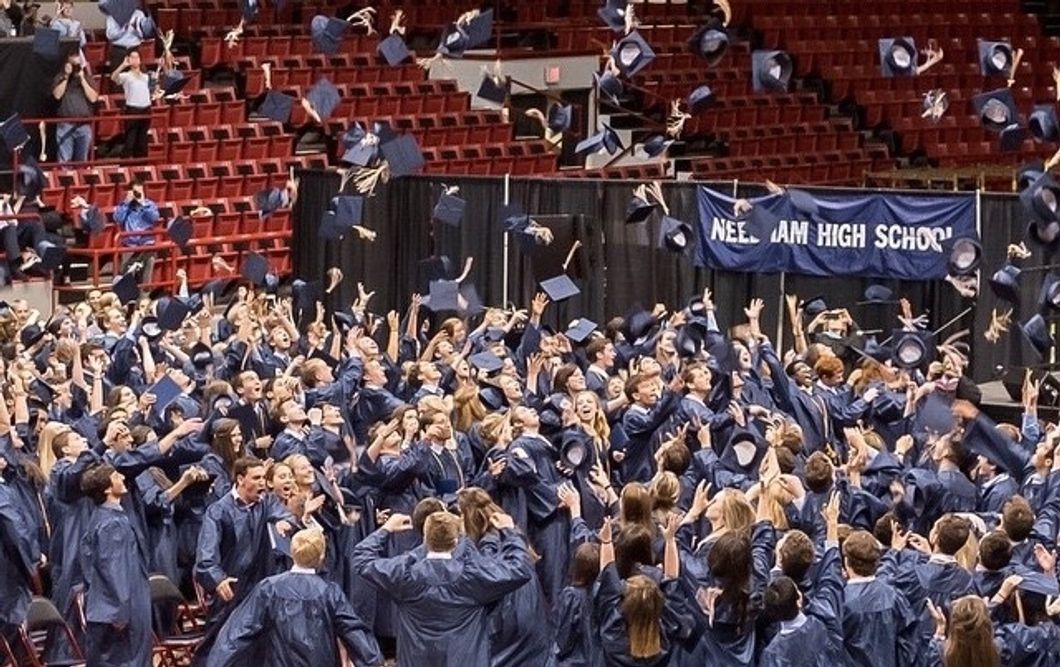 Graduates throwing their mortarboards in the air