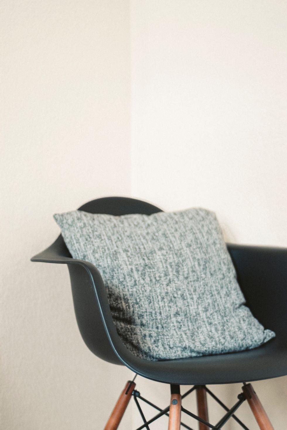 gray and white throw pillow on black leather armchair